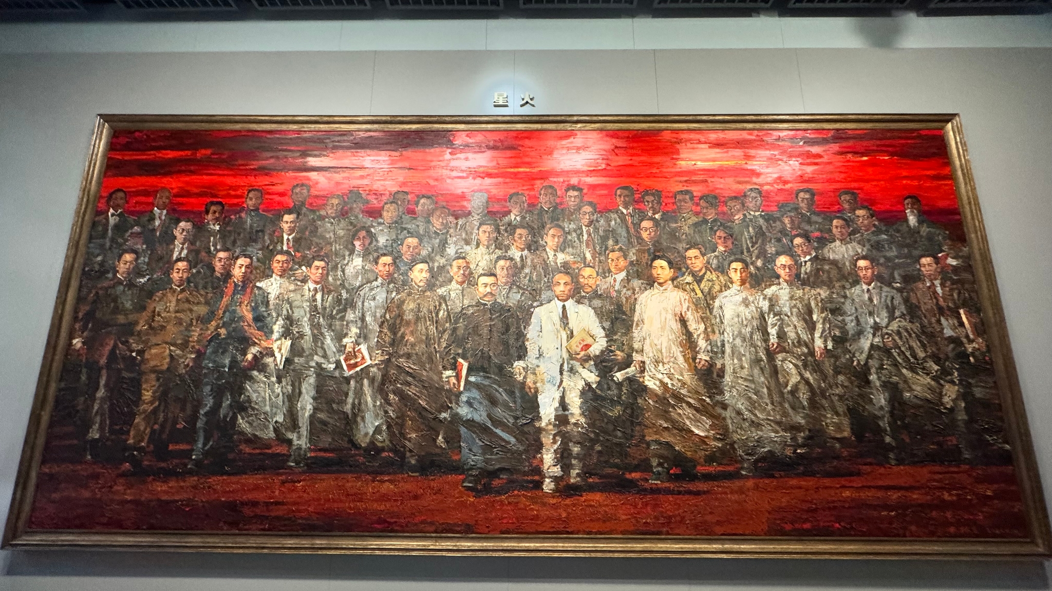 A large, framed painting depicting a group of people in historical attire, set against a vivid red background