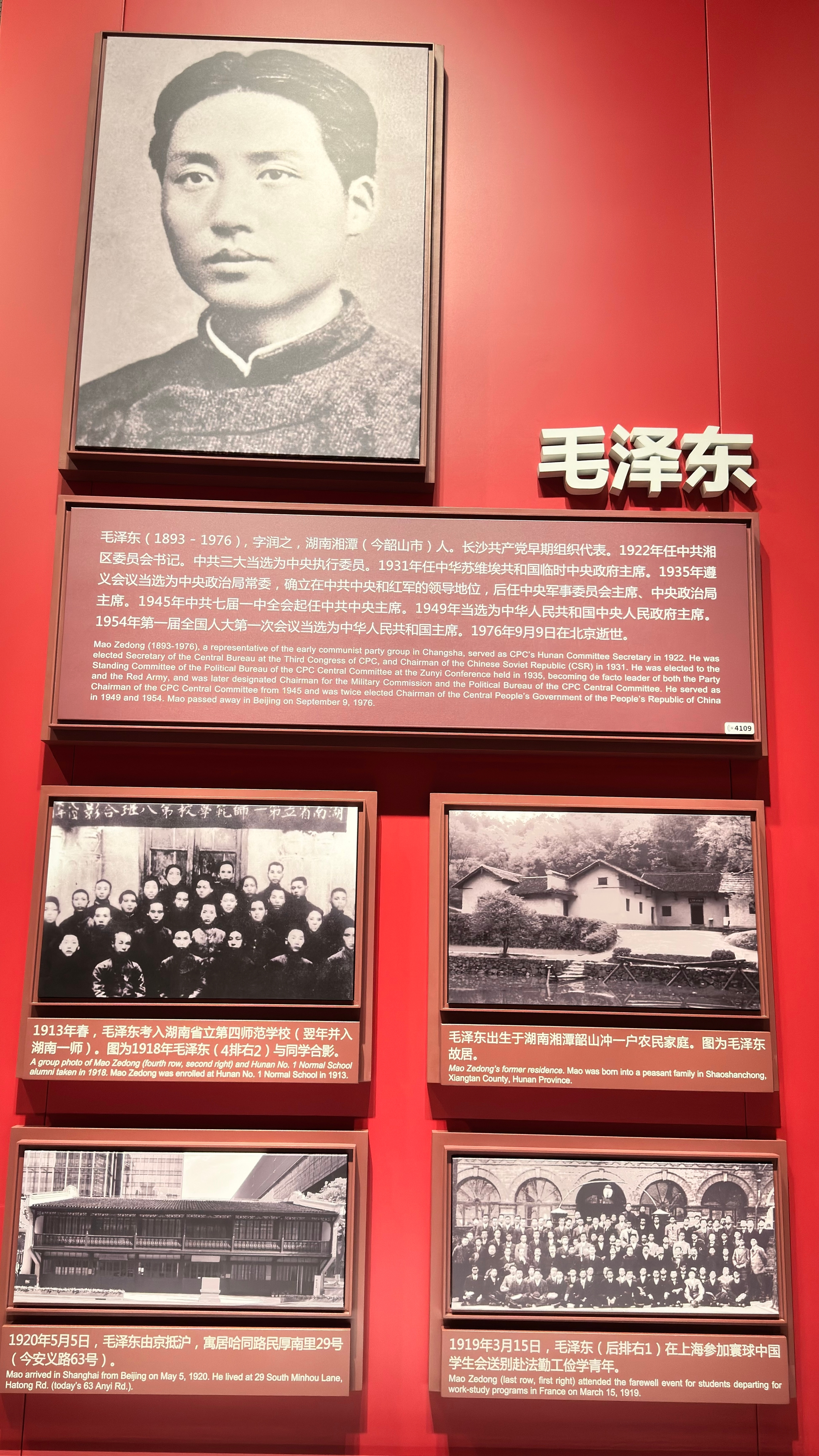 A display featuring a large portrait of a young man, accompanied by text in Chinese and several smaller historical photographs, all set against a red background