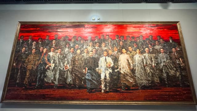 A large, framed painting depicting a group of people in historical attire, set against a vivid red background