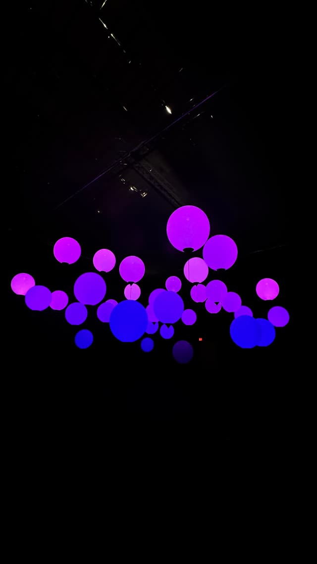Glowing purple and blue spheres suspended in a dark space